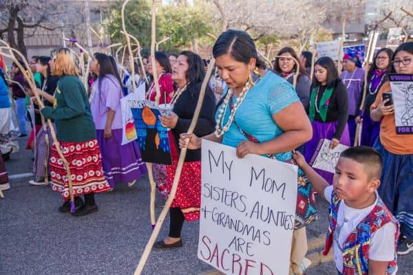 kultursensibel reisen: eine gruppe indigener frauen und ein kind, die mit stöcken und schildern demonstrieren